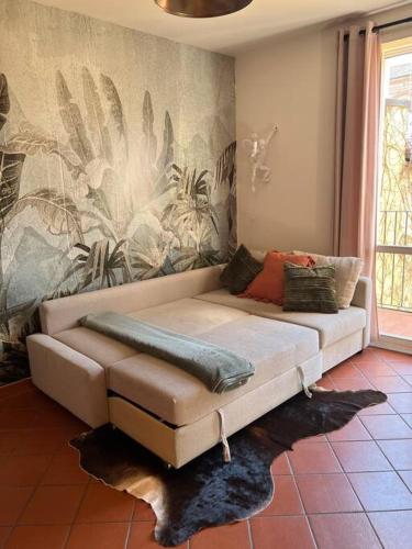 a couch in a living room with a mural at AnyHome Oasi in città in Imola