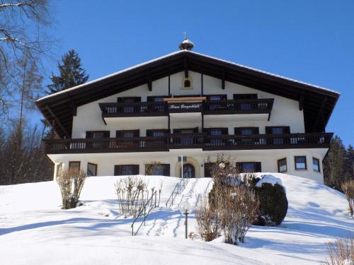 ein großes weißes Gebäude im Schnee mit Schnee in der Unterkunft Ferienwohnung für 3 Personen ca 46 m in Oberaudorf, Bayern Oberbayern in Oberaudorf