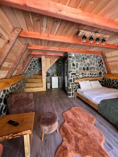 a bedroom in a log cabin with a bed and a table at Serona Apart & Bungalow in Çamlıhemşin