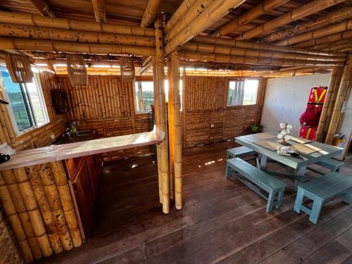 um quarto com uma mesa e um banco numa cabina em Casa Coral em Mayapo