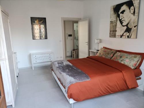 una camera da letto con un grande letto con una coperta arancione di Maison de Famille a Torino