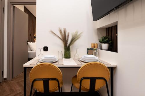 uma cozinha com duas cadeiras e uma mesa com pratos em LP Luxury Citycenter Apartment em Serres