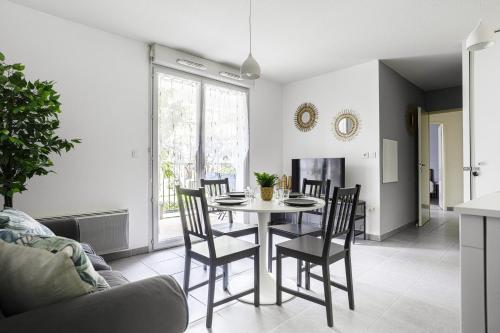 une salle à manger avec une table et des chaises dans l'établissement Le Cocon Verdoyant, à Toulouse