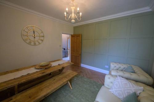 a living room with a couch and a clock on the wall at Number 2 in Mountain Ash