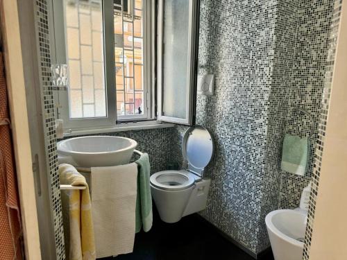 ein Bad mit einem WC, einem Waschbecken und einem Fenster in der Unterkunft Azadi Rome Center in Rom