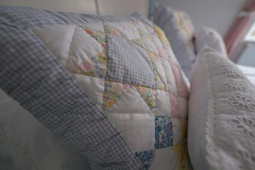 a bed with a quilt and a pillow on it at Number 2 in Mountain Ash