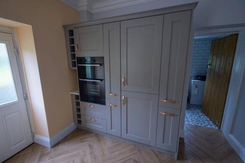 a kitchen with a large cabinet with a microwave at Number 2 in Mountain Ash