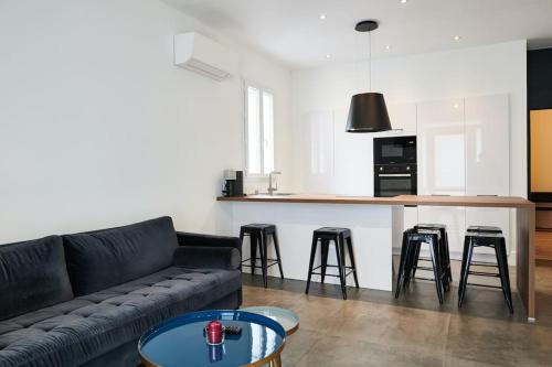 un salon avec un canapé et une cuisine dans l'établissement Ancien conservatoire, à Sète