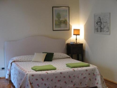 a bedroom with a bed with green pillows on it at B&B A Casa Di Andrea in Mantova