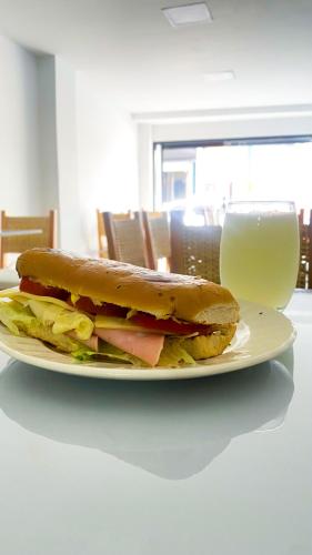 a sandwich on a plate next to a glass of milk at Maidy Luxury Hotel in Medellín