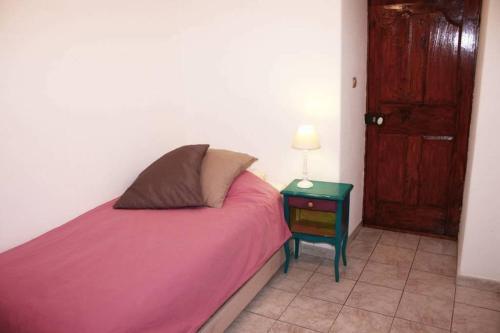 une chambre avec un lit et une table avec une lampe dans l'établissement Charme du village-Plage à 10mn, à Corbara