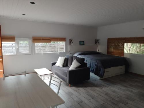 a bedroom with a bed and a couch at La Escondida in Valeria del Mar