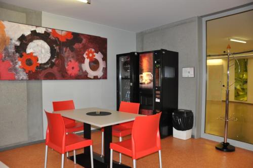 a dining room with a table and red chairs at MOTEL ARBOTEL 24h self check-in in Friesach