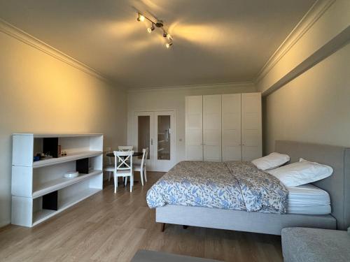 een slaapkamer met een bed, een bureau en een tafel bij Studio Winston Churchill in Brussel