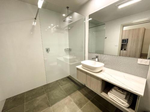 a bathroom with a sink and a glass shower at Elimatta Hotel in Devonport