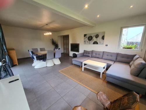 un salon avec un canapé et une table dans l'établissement Grande maison champêtre à 2 min de la voie express, à Landivisiau