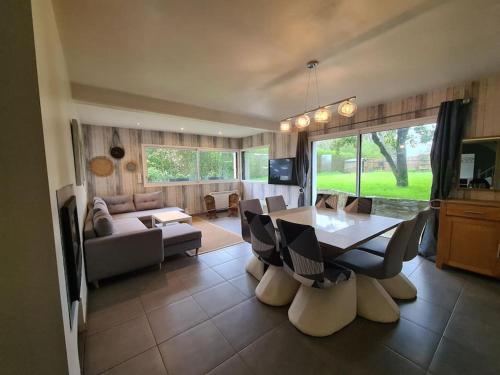 un salon avec une table et un canapé dans l'établissement Grande maison champêtre à 2 min de la voie express, à Landivisiau