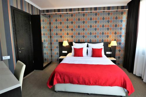a bedroom with a large bed with red pillows at East Gate Boutique Hotel in Tbilisi City