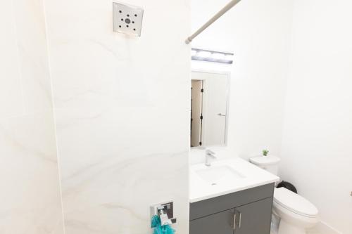 uma casa de banho com um lavatório e um espelho em Chic 2-Bed Getaway Home-mins to NYC em Bayonne
