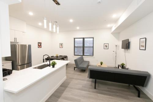uma cozinha e sala de estar com paredes brancas em Chic 2-Bed Getaway Home-mins to NYC em Bayonne