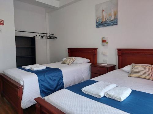 a room with three beds with towels on them at Hotel Islas Galapagos in Puerto Baquerizo Moreno