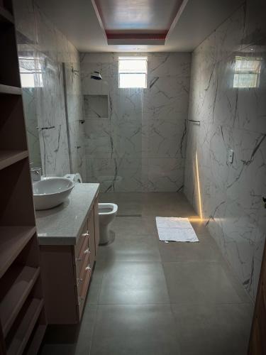 ein Bad mit einem Waschbecken, einem WC und einer Dusche in der Unterkunft Residencial Mirandinha. in Boa Vista