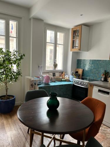 une petite cuisine avec une table et une table sidx sidx sidx dans l'établissement Calm apartment in great location, à Paris