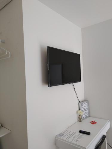 una TV a schermo piatto in cima a un muro bianco di Zion inn economy 2 a Saint John