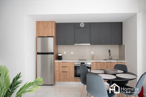 a kitchen with black cabinets and a table with chairs at Agora Central Home in Chalkida