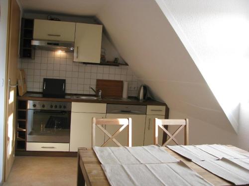 een keuken met een fornuis en een tafel met 2 krukken bij Moderne Ferienwohnung mitten in der Greifswalder Innenstadt in Greifswald