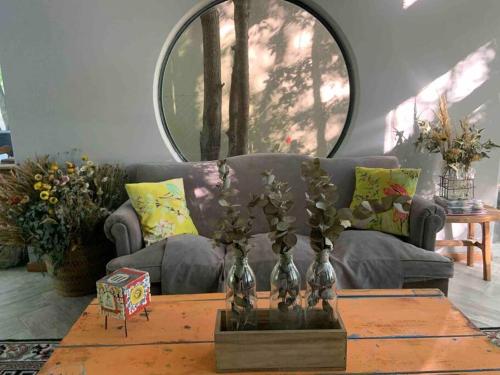 a living room with a couch and a table with flowers at Loft moderno en medio del bosque in Arturo SeguÃ­