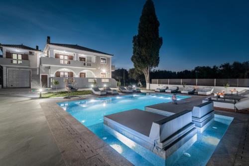a house with a swimming pool at night at Villa Olympia in Pandokrátor