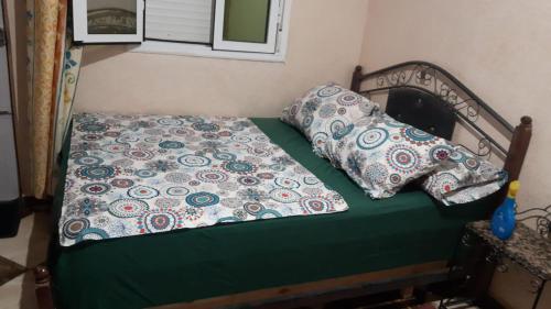 ein Bett mit zwei Kissen darauf in einem Schlafzimmer in der Unterkunft ضيافة سيدي حمزة Maison d'hôtes in Tazrouft