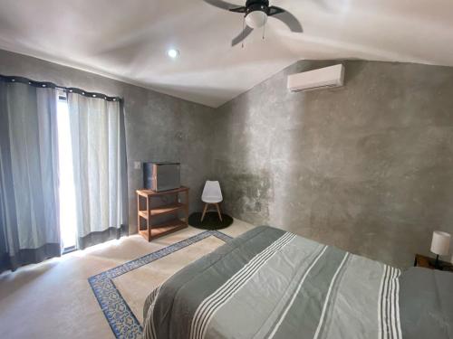 a bedroom with a bed and a ceiling fan at Casa Costa Rosa - Habitación Mar in Yuluc