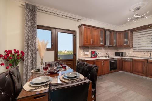 a kitchen and dining room with a table and chairs at Villa Olympia in Pandokrátor