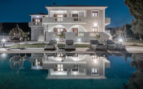 uma villa com piscina à noite em Villa Olympia em Pandokrátor