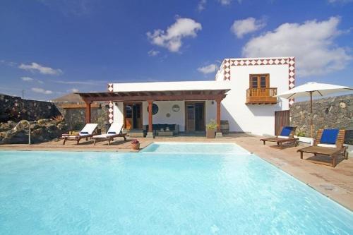 eine Villa mit einem Pool und einem Haus in der Unterkunft Sehr großzügig und modern eingerichtetes Ferienhaus mit privatem Pool und Sonnenterrassen im eigenen Garten in Tías