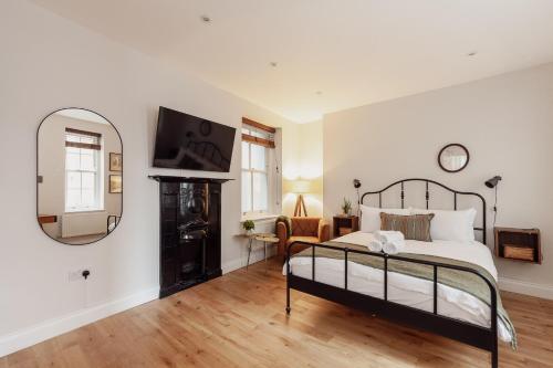 a bedroom with a large bed and a mirror at Holborn Townhouse in London