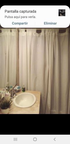 uma casa de banho com um lavatório e uma cortina de chuveiro em Las Magnolias em Ingeniero Maschwitz