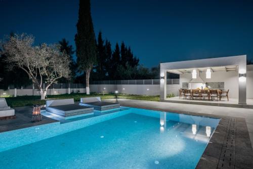 a house with a swimming pool at night at Villa Olympia in Pandokrátor