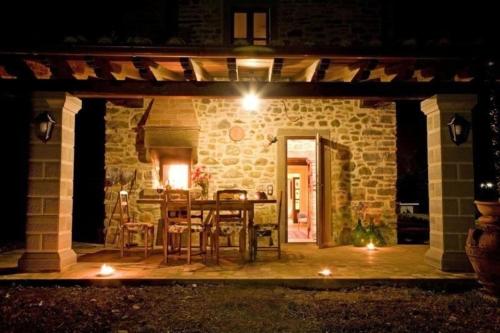 un patio esterno con tavolo e sedie di notte di Ferienhaus mit Privatpool für 2 Personen ca 70 qm in Poppi, Toskana Provinz Arezzo a Poppi