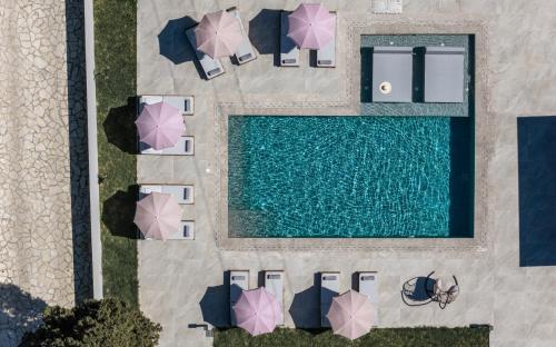 an overhead view of a swimming pool with umbrellas at Villa Olympia in Pandokrátor