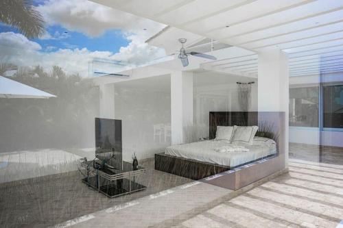 Habitación blanca con cama y TV en Villa con piscina en frente al mar con servicios en San Carlos