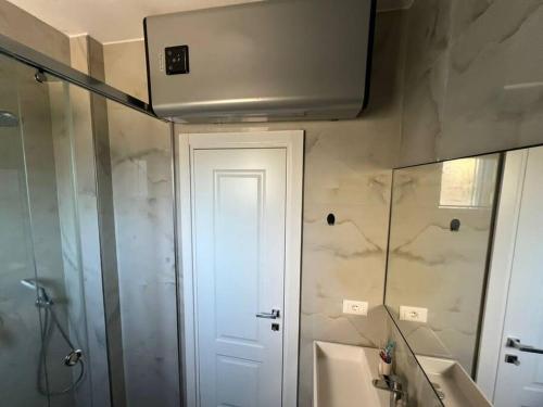 La salle de bains est pourvue d'une douche, d'un lavabo et d'un miroir. dans l'établissement Apartmán Holly, à Golem
