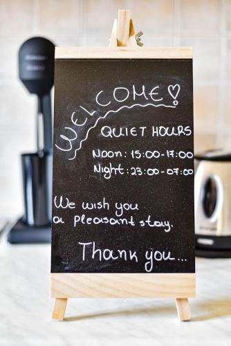 a chalkboard sign that says goodbyeuart hours at DP Homes Santorini in Perissa