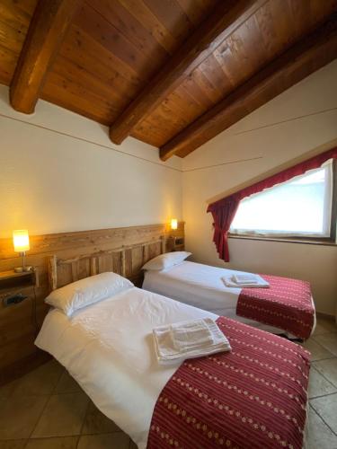 um quarto de hotel com duas camas e uma janela em BAITA ARIANNA - BILOCALE MOTTA em Sestriere