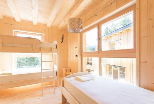 a bedroom with a bunk bed and two windows at Chalet PINO in Tret