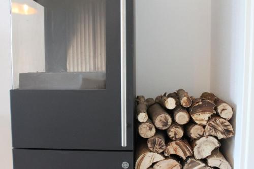 a pile of fire wood next to a refrigerator at Appartement "Am Schlosshang" mit Terrasse in Waldmünchen