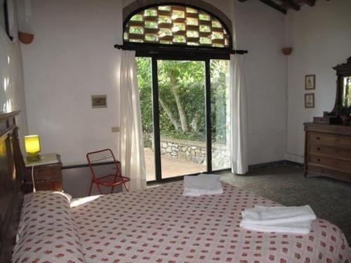 een slaapkamer met een bed en een groot raam bij Ferienwohnung in Barberino Tavarnelle mit Privatem Garten - b58103 in San Donato in Poggio