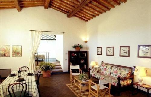 een woonkamer met een bank en een tafel bij Ferienwohnung in Barberino Tavarnelle mit Privatem Garten - b58103 in San Donato in Poggio